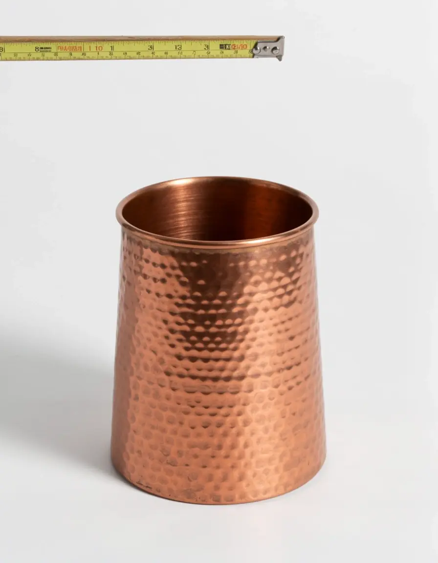 Tazas medidoras de cobre martillado sobre una mesa de repostería